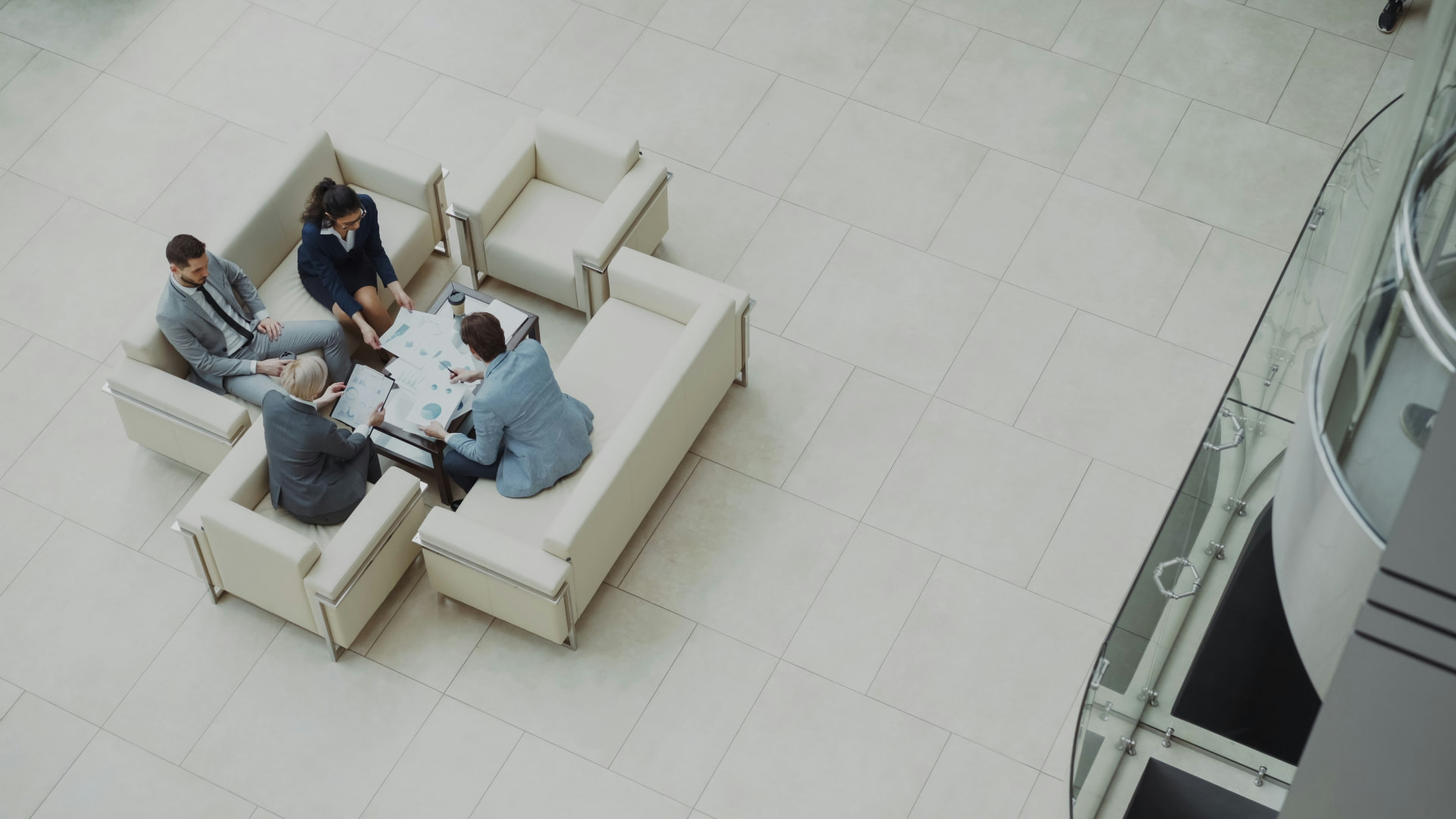 Vier mensen bespreken samen analyses en grafieken aan een tafel